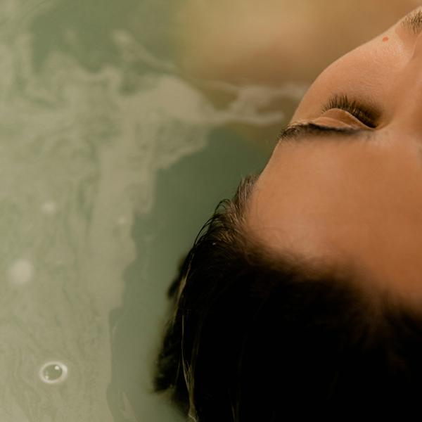 restorative yin yoga close up of woman's face floating in water